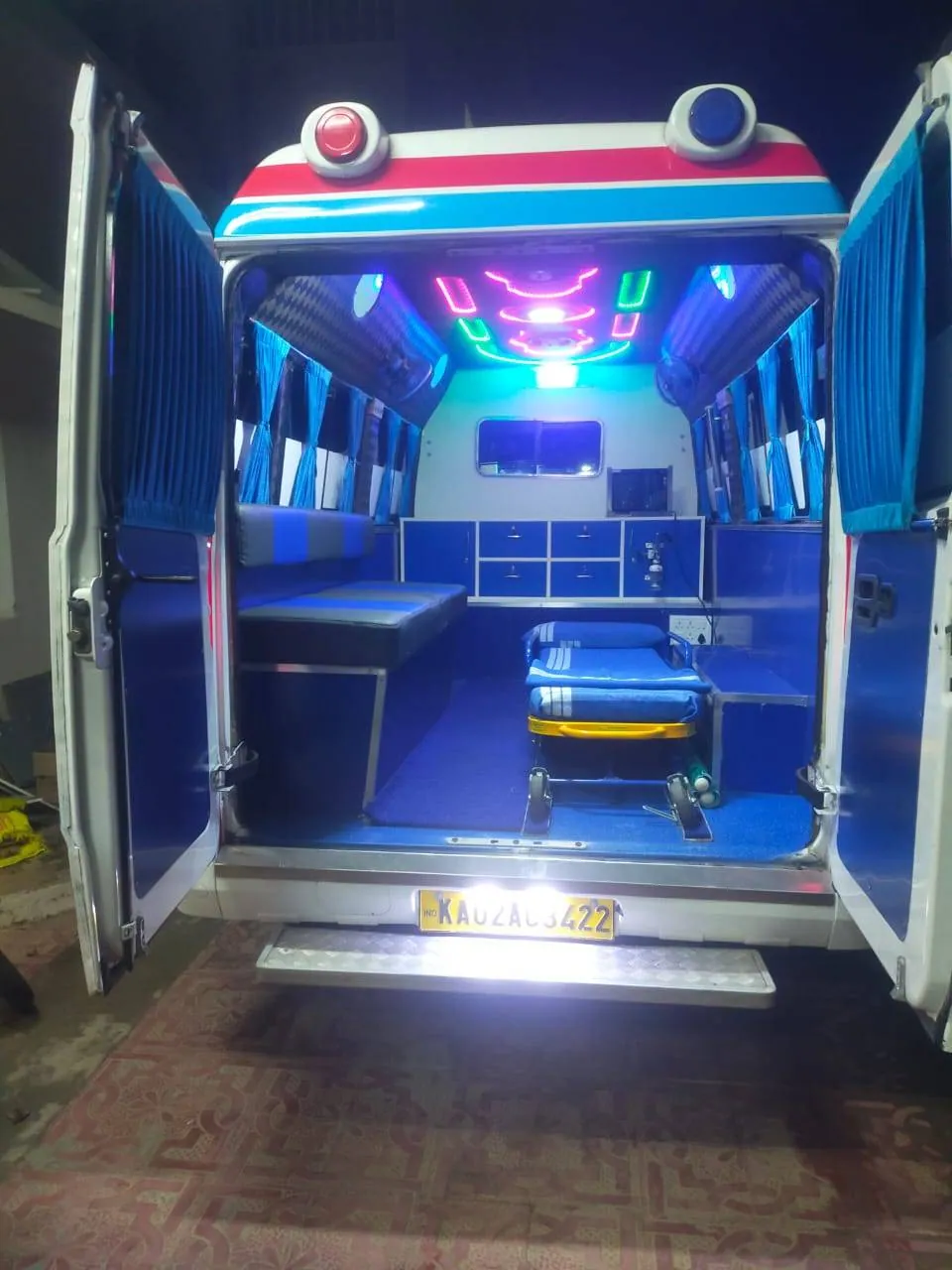 Ambulance interior with wheeled stretcher, lit and ready at night