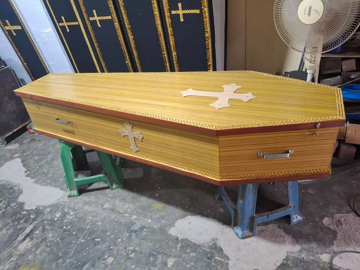 Golden wooden coffin with cross
