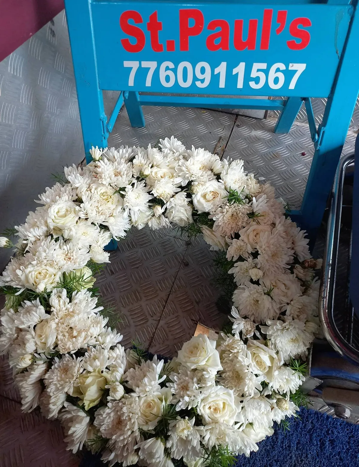 White funeral wreath of roses and chrysanthemums prepared by St Paul's